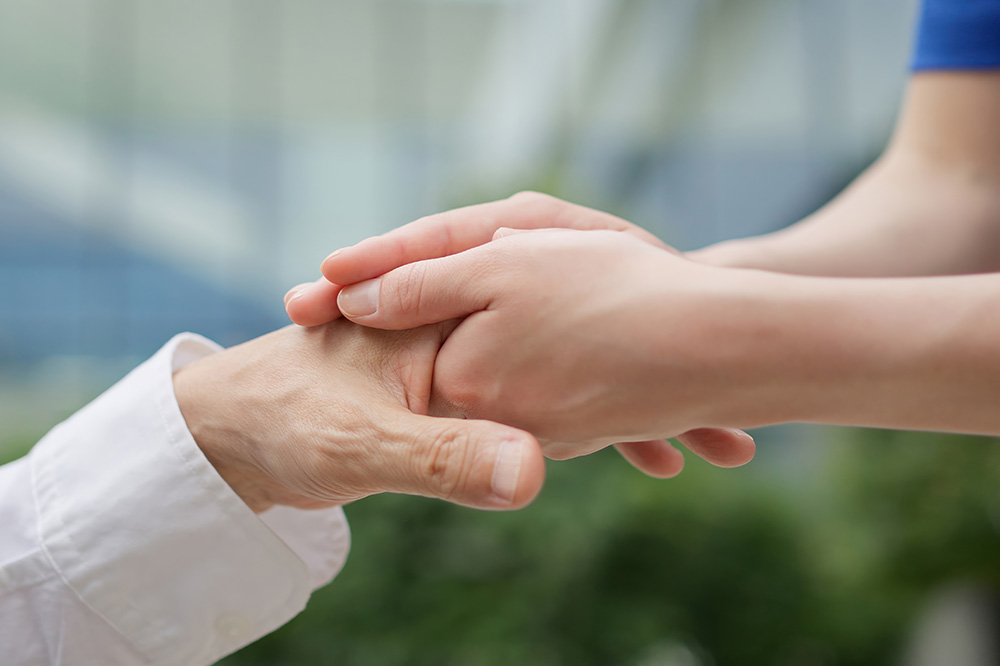 Caregiver's hands reaching out to the elderly